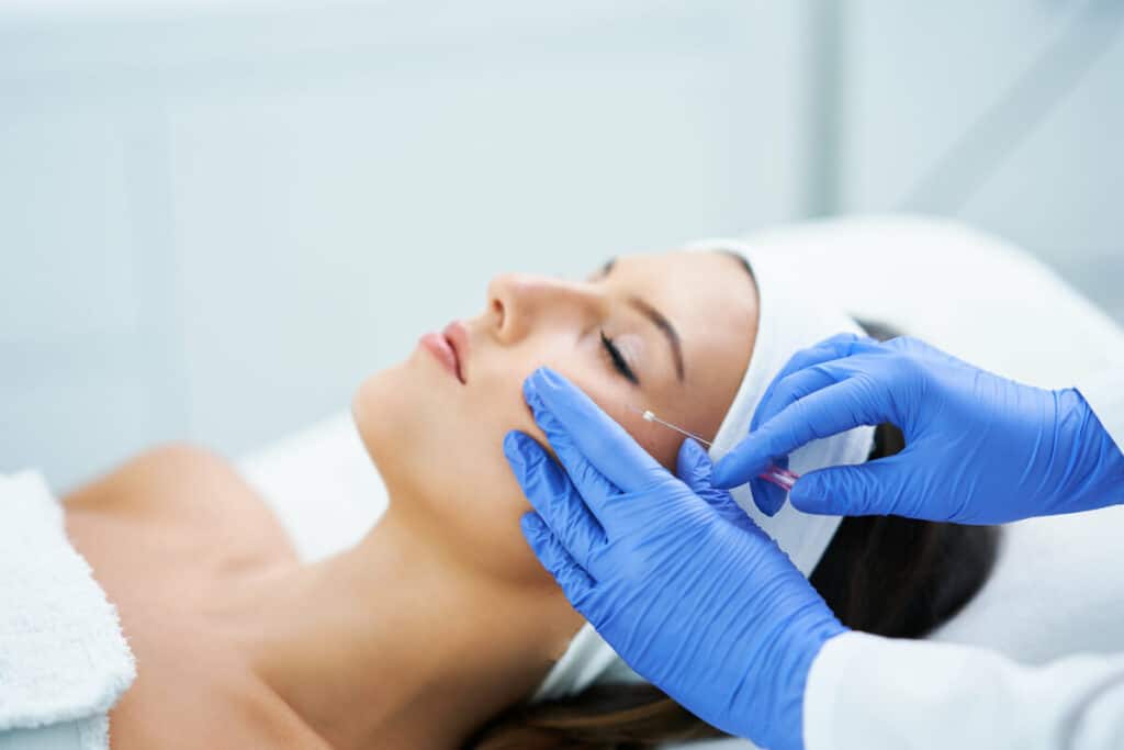 ¿Alguna vez has deseado que un hilo invisible levantara tu mirada o te ayudara a conseguir un óvalo facial más definido, con menos arrugas? La medicina estética lo hace realidad gracias a los hilos tensores, uno de los tratamientos de rejuvenecimiento facial más innovadores. ¿Habías oído hablar de ellos? En este artículo te contamos qué son, cómo funcionan y en qué casos merecen la pena los hilos tensores como rejuvenecimiento facial sin cirugía. ¿Qué son los hilos tensores? Los hilos tensores son unos hilos muy finos, que se utilizan en Medicina Estética para rejuvenecer el rostro gracias a la eliminación de arrugas y flacidez facial, el levantamiento de cejas, la redefinición del óvalo facial y el contorno de la mandíbula. Podemos diferenciar dos tipos de hilos: Los hilos tensores permanentes, hechos de propileno. Hilos tensores temporales de diaxanona. Este material se reabsorbe con el tiempo por el organismo sin necesidad de ningún procedimiento para su retirada o modificación. El efecto que consigue este tratamiento es como el de un lifting, con la ventaja de no tener que pasar por quirófano, ni por una operación invasiva y complicada. ¿Cuándo están indicados? El tratamiento con hilos tensores se realiza en los siguientes casos: Cuando se desean disimular las arrugas del contorno de los ojos Elevar las mejillas Reafirmar el cuello Conseguir una mayor asimetría Difuminar arrugas de la frente Reafirmar el contorno facial Procedimiento del tratamiento con hilos tensores Antes de realizar la intervención, nuestros especialistas en medicina estética proceden a hacer una evaluación inicial. Durante esta evaluación, conocemos los objetivos y preocupaciones del paciente y determinamos la idoneidad del tratamiento. La intervención de hilos tensores generalmente se realiza bajo anestesia local para minimizar las molestias durante el procedimiento. En algunos casos, se puede utilizar anestesia tópica para adormecer la zona tratada. Hay diferentes tipos de hilos tensores disponibles, y la elección depende de los objetivos específicos del paciente y la zona a tratar. Los hilos pueden ser de polidioxanona (PDO), ácido poliláctico u otros materiales que estimulan la producción de colágeno. Una vez que la anestesia ha hecho efecto, el médico especialista realiza pequeñas incisiones en la piel para insertar los hilos tensores en la capa subcutánea. Estos hilos tienen pequeños ganchos o conos que se enganchan en los tejidos para levantar y tensar la piel. Los hilos tensores se ajustan y tensan la piel al ser manipulados por el médico. El objetivo es reposicionar los tejidos faciales, mejorar la flacidez y estimular la producción de colágeno para obtener resultados más duraderos. Una vez que los hilos se han colocado y ajustado correctamente, se cierran las pequeñas incisiones con suturas absorbibles. Antes y después de los hilos tensores El post-tratamiento puede ser molesto y aparecer hinchazón en las zonas tratadas, aunque lo habitual es que no cause molestias. El tiempo de recuperación después de la intervención de hilos tensores es generalmente breve. Pueden ocurrir algunos efectos secundarios temporales como hinchazón, hematomas o molestias, pero estos suelen desaparecer en pocos días. Los resultados finales de la intervención con hilos tensores no son inmediatos. A medida que los hilos se disuelven, estimulan la producción de colágeno, lo que mejora la firmeza y la textura de la piel de manera gradual. Después del procedimiento, se programan citas de seguimiento para evaluar la evolución de los resultados y abordar cualquier inquietud del paciente. Conclusión Si deseas reafirmar tu contorno facial, levantar tu mirada, elevar las mejillas o difuminar las arrugas de la frente, no dudes en contactar con nosotros y pedir una cita de valoración. En nuestra clínica de estética en Jaén estaremos encantados de informarte sobre el tratamiento de hilos tensores, para rejuvenecer tu rostro sin cirugía.